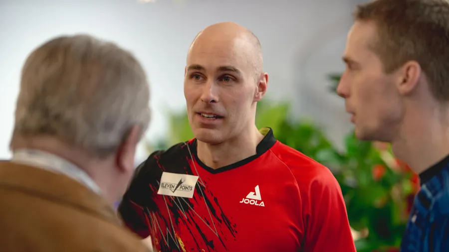 Guests in conversation, one wearing a name badge