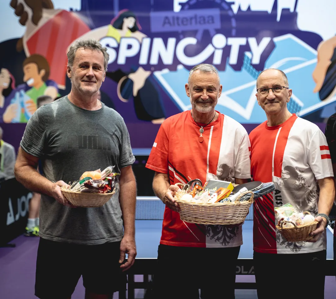 Siegerehrung bei den SpinCity Masters: Gewinner mit Geschenkkörben vor der SpinCity-Wand